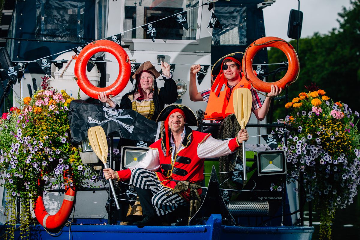 People joyfully holding lifeguard and boating equipments